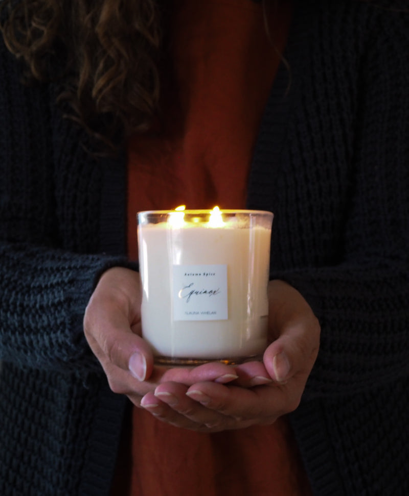hands holding lit fall spice equinox soy luxury candle