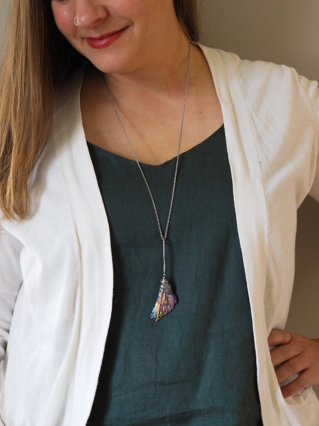 woman wearing blue top with rainbow besom witches broom healing crystal talisman necklace