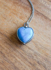 blue gemstone crystal heart necklace talisman on wooden background