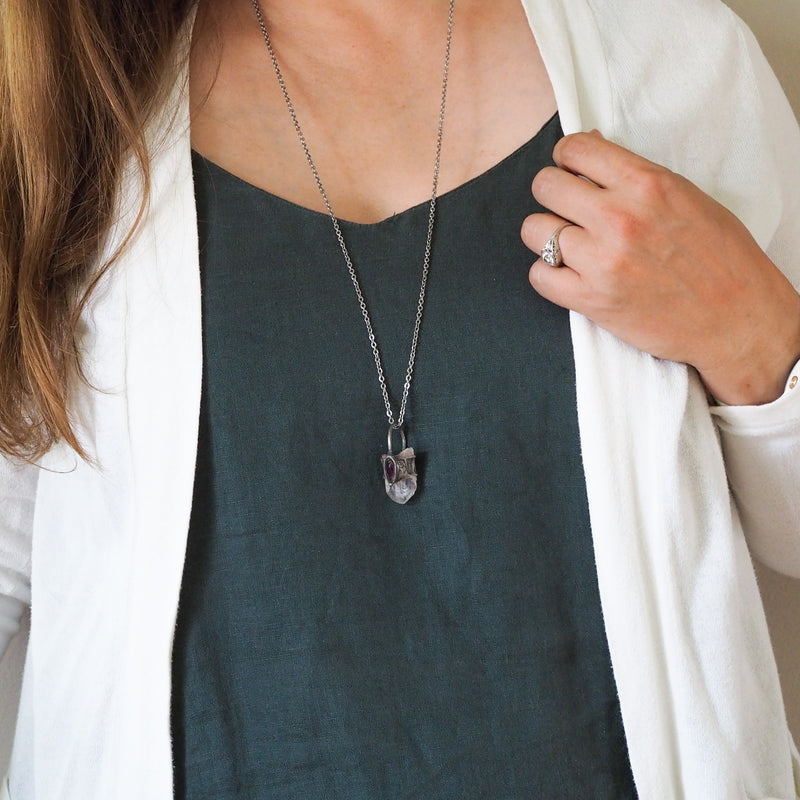 healing crystal talisman necklace on woman in blue top