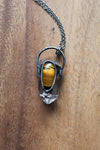 rustic clear and banded yellow healing crystal talisman necklace on wooden background