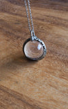 healing crystal orb crystal talisman necklace on wooden background
