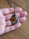 orange crystal talisman necklace in palm of hand