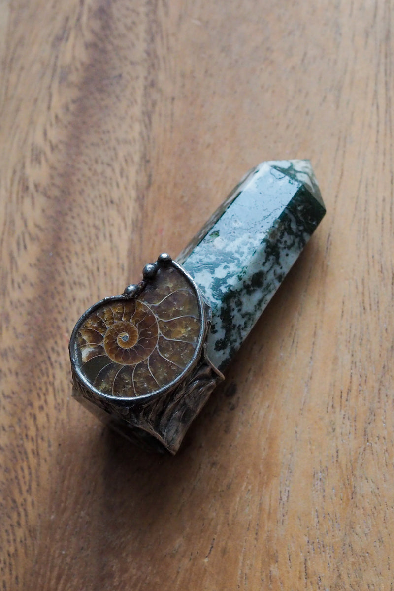green, white, and brown healing crystal wand on wooden background