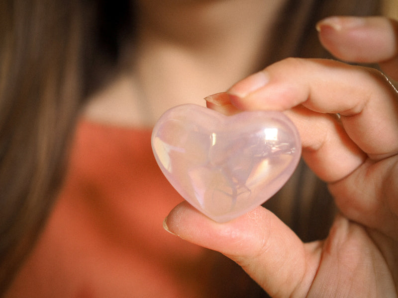 woman's hand holding crystal heart