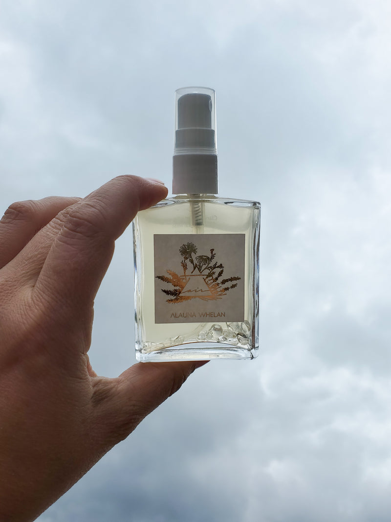 air sign crystal infused ritual mist held up against a cloudy sky