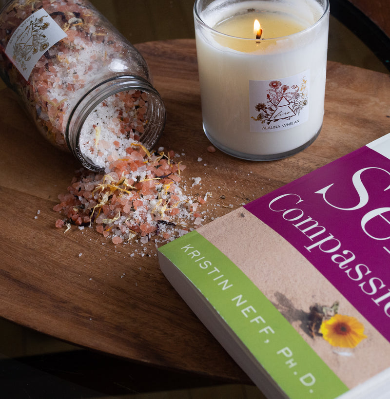 Alauna Whelan fire candle, bath soak, and book on wooden tray
