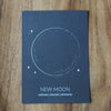 grey new moon lunar print on wooden background