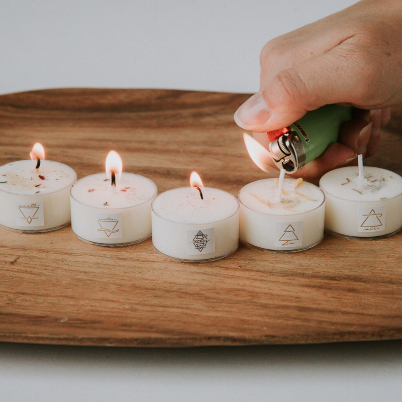 hand lighting five soy intention tealights on wooden tray 