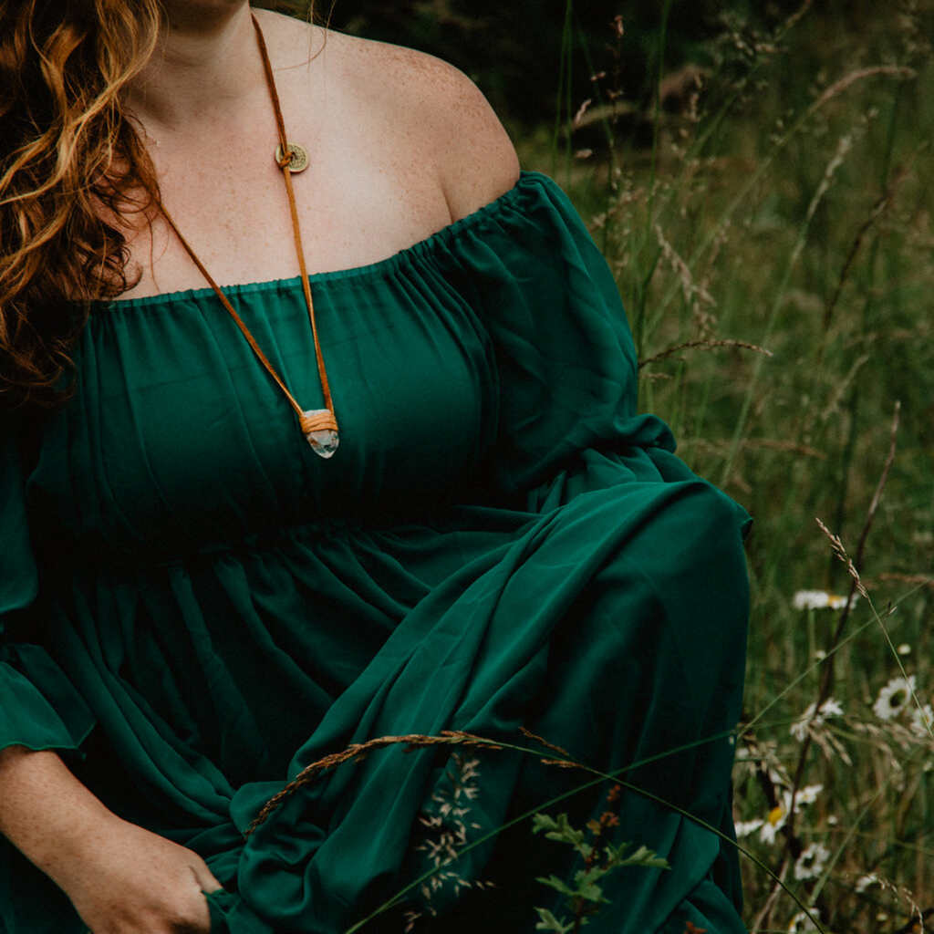 Woman in green dress with leather and quartz necklace
