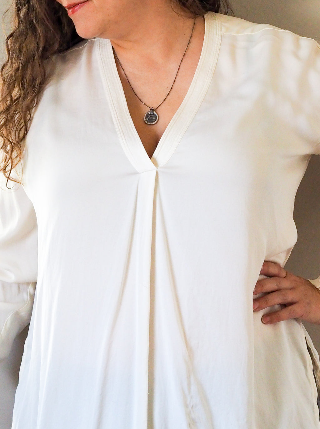 air sign silver necklace woman in white top