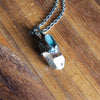 blue and clear healing crystal talisman necklace on wooden background