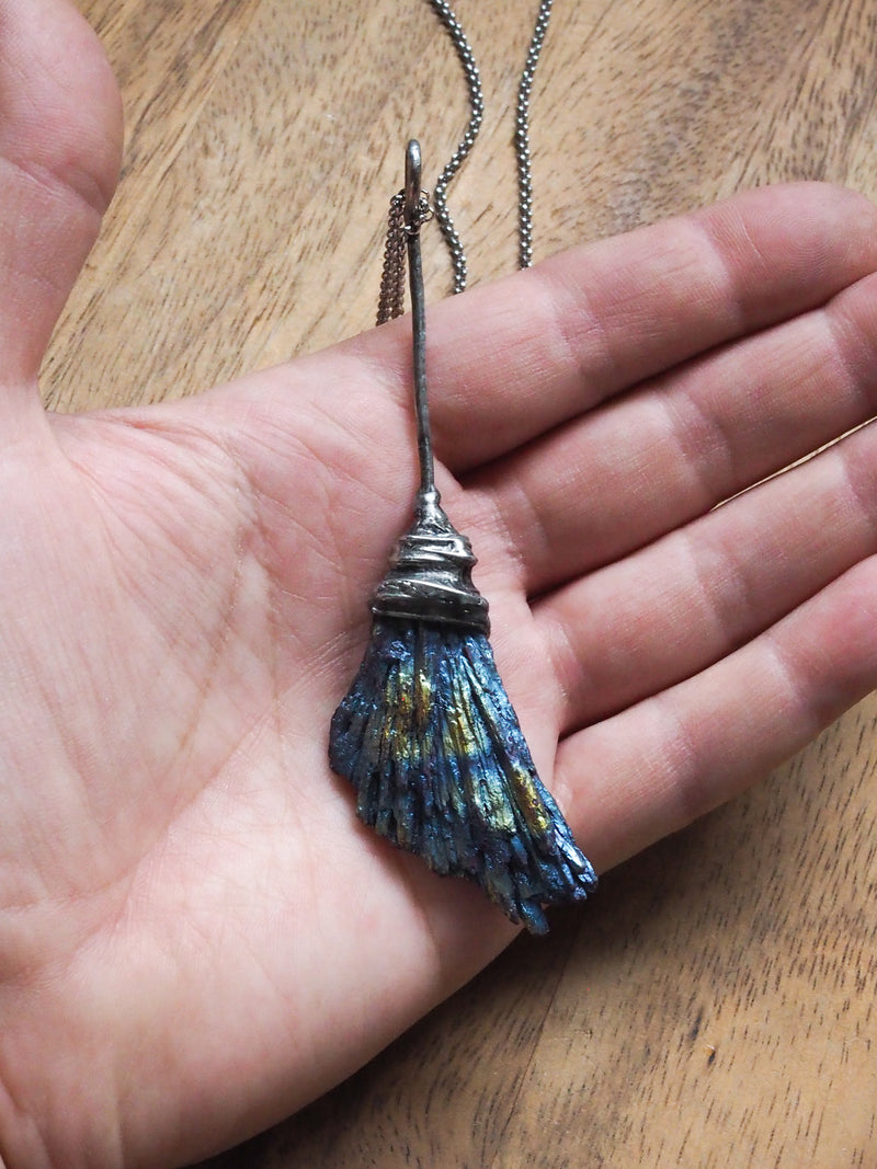 hand holding rainbow besom witches broom healing crystal talisman necklace