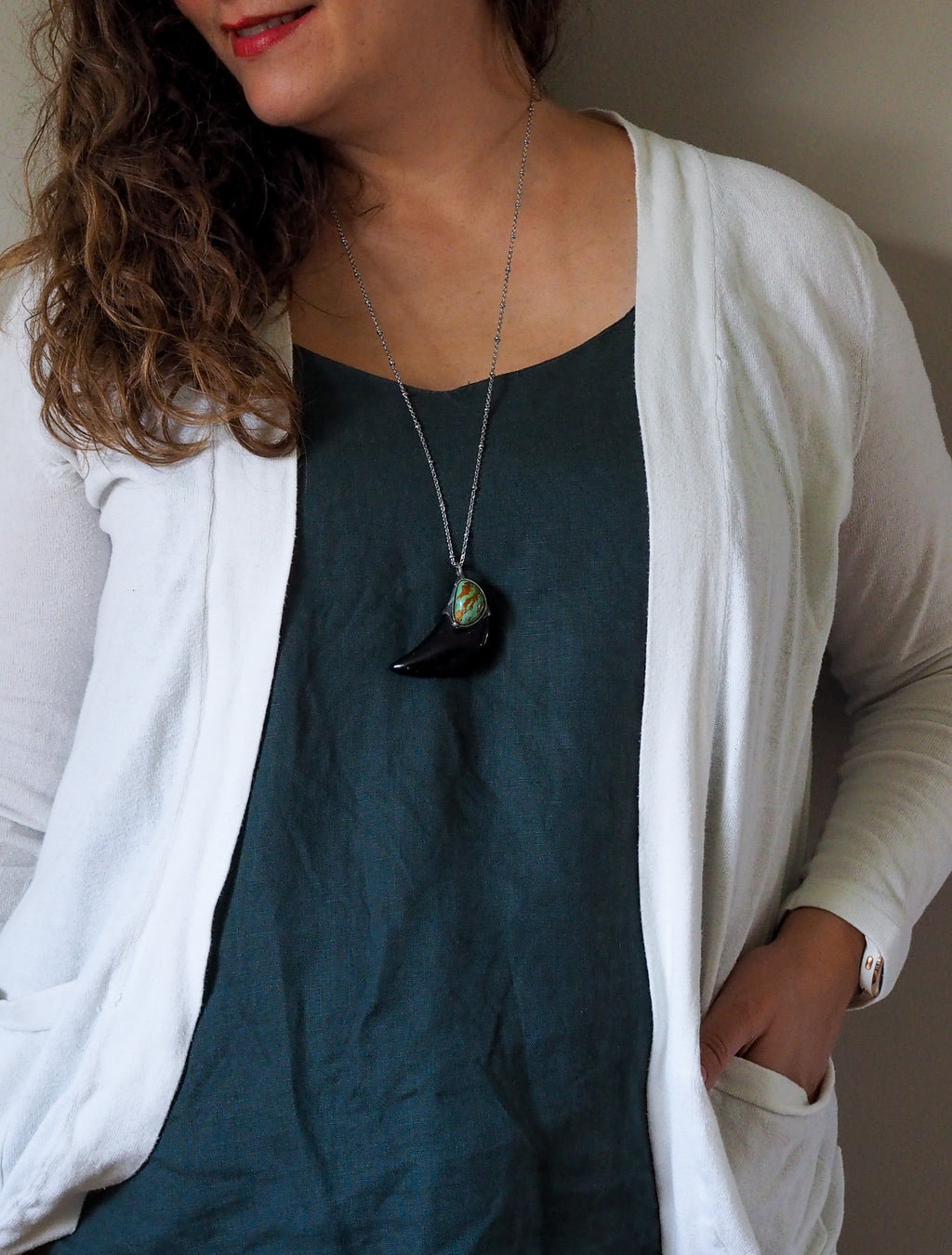 black and blue healing crystal talisman necklace on woman in blue top