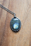 blue and green flashy labradorite gemstone healing crystal talisman statement necklace on wooden background