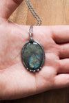 blue and green flashy labradorite gemstone healing crystal talisman statement necklace on palm of hand