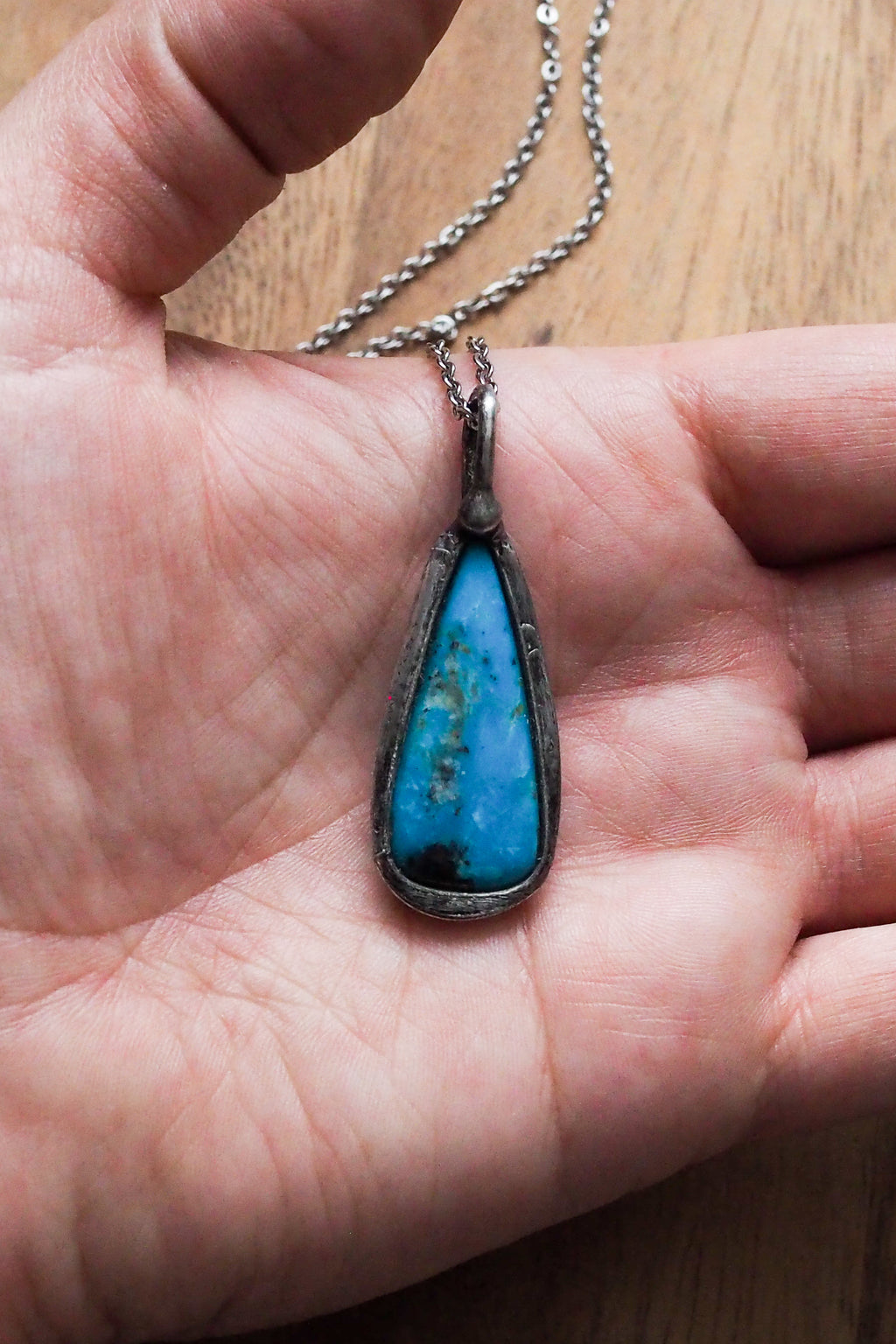bright blue kingman turquoise gemstone healing crystal talisman statement necklace on palm of hand