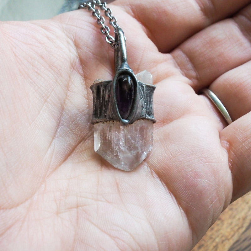 healing crystal talisman necklace in palm of hand