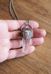 clear and blue healing protection crystal talisman necklace in palm of hand