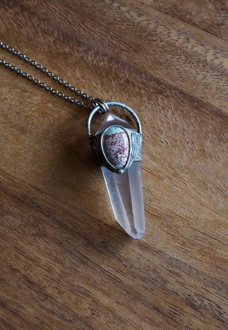 clear and blue healing protection crystal talisman necklace on wooden background