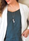 clear and blue healing protection crystal talisman necklace on woman in blue top