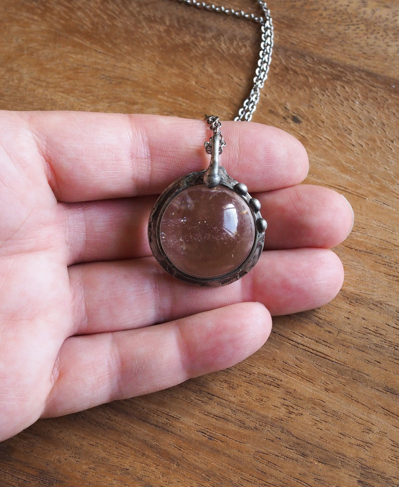 healing crystal orb crystal talisman necklace in palm of hand