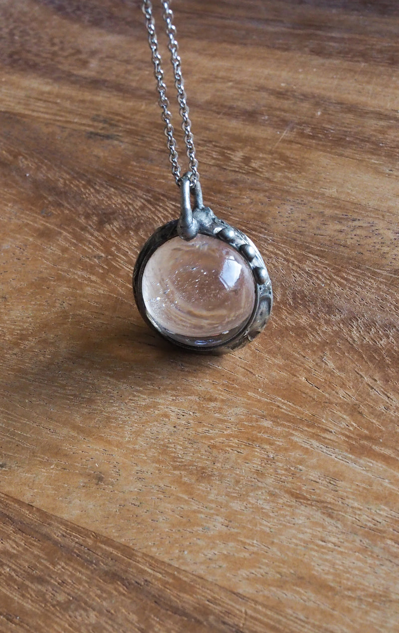 healing crystal orb crystal talisman necklace on wooden background