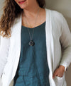 healing crystal orb crystal talisman necklace on woman in blue top