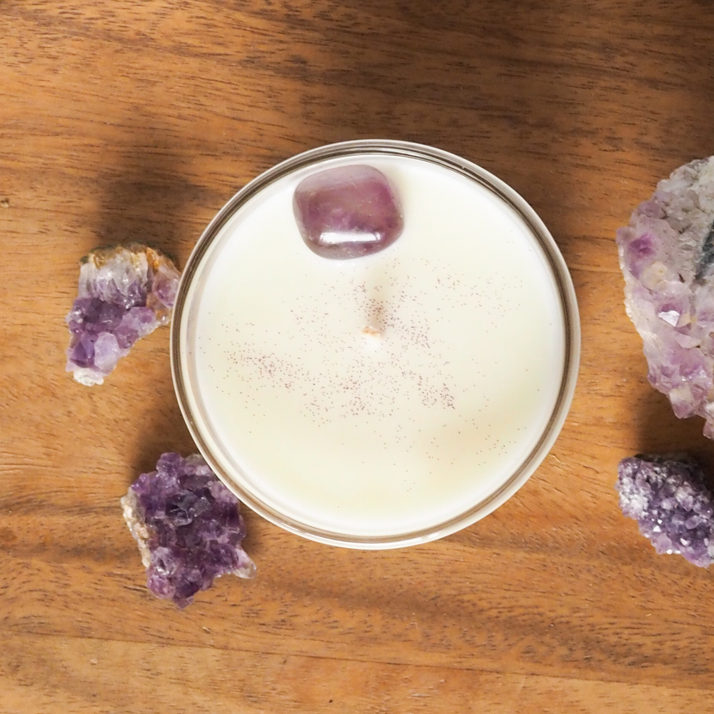 birds eye view of divinity ether soy candle on wooden tray with purple amethyst crystals