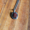 ruby healing crystal talisman necklace on wooden background