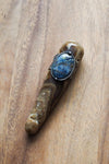 brown and blue healing crystal talisman wand on wooden background