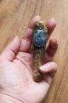 hand holding brown and blue healing crystal talisman wand