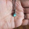 small blue turquoise healing crystal talisman necklace in palm of hand