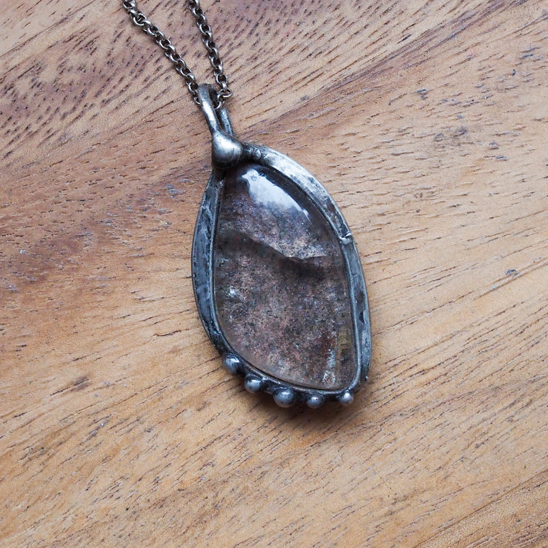 garden quartz healing crystal talisman necklace on wooden background