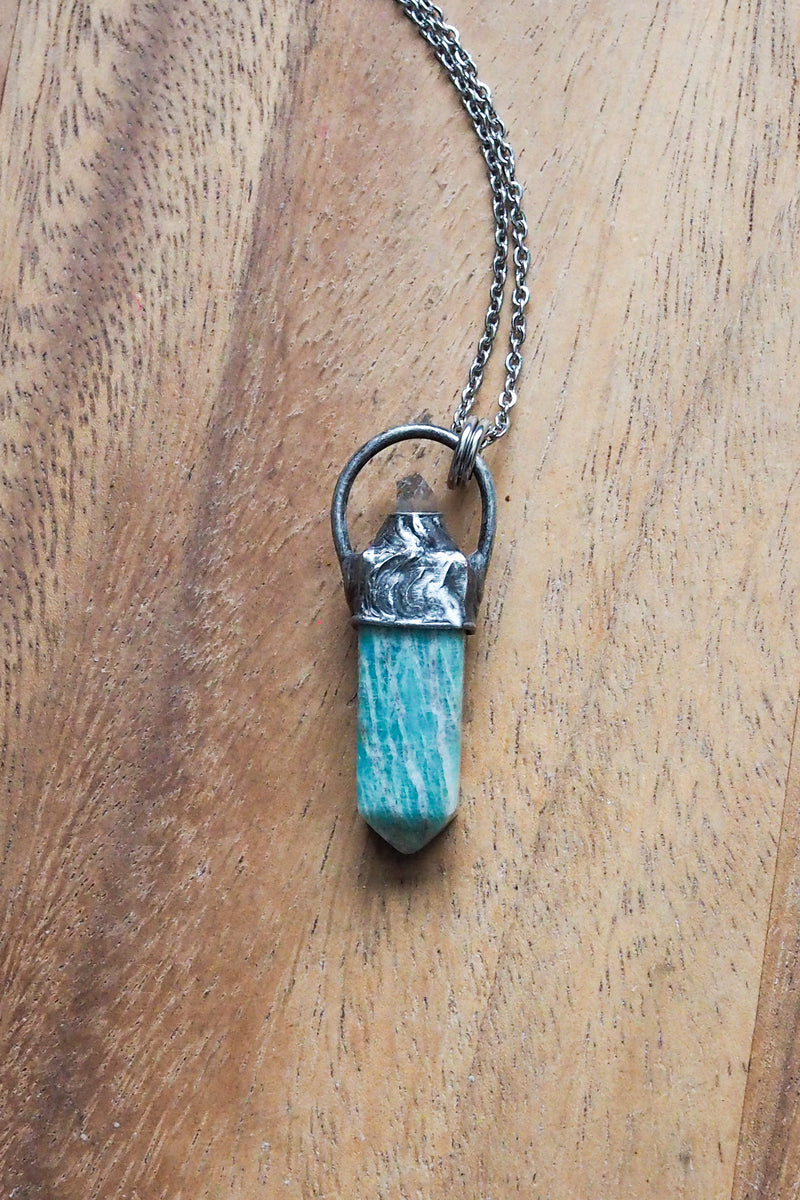 teal green gemstone healing crystal talisman necklace on wooden tray