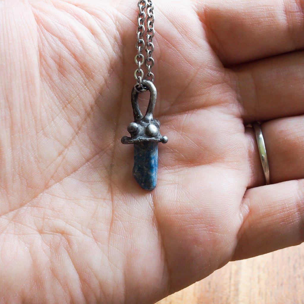 blue lapis lazuli mushroom healing crystal talisman necklace in palm of hand