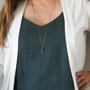 blue lapis lazuli healing crystal talisman necklace on woman in blue top