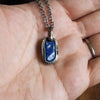 blue lapis lazuli healing crystal talisman necklace in palm of hand
