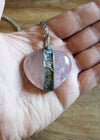 light pink rose quartz heart gemstone talisman necklace in palm of hand