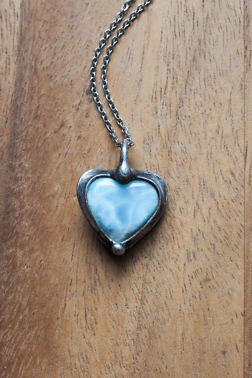 soft pale blue larimar healing crystal talisman necklace on wooden background