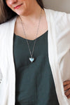 soft pale blue larimar healing crystal talisman necklace on woman in blue top with white cardigan
