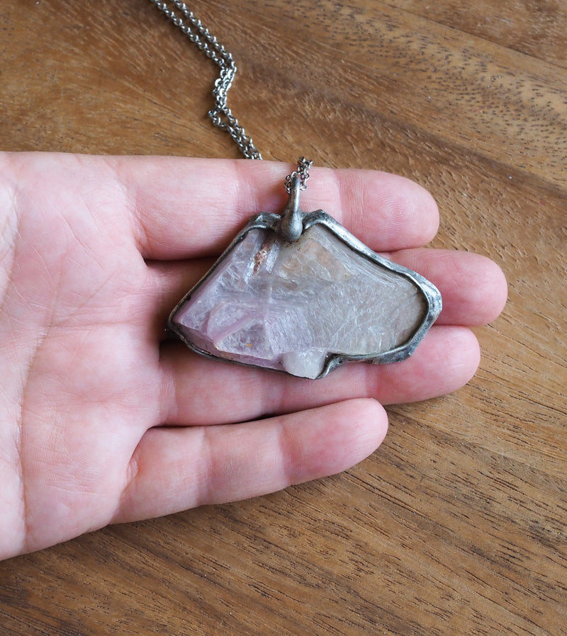 lilac purple lepidolite raw crystal talisman necklace in palm of hand