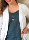 soft purple gemstone crystal talisman necklace on woman in blue top