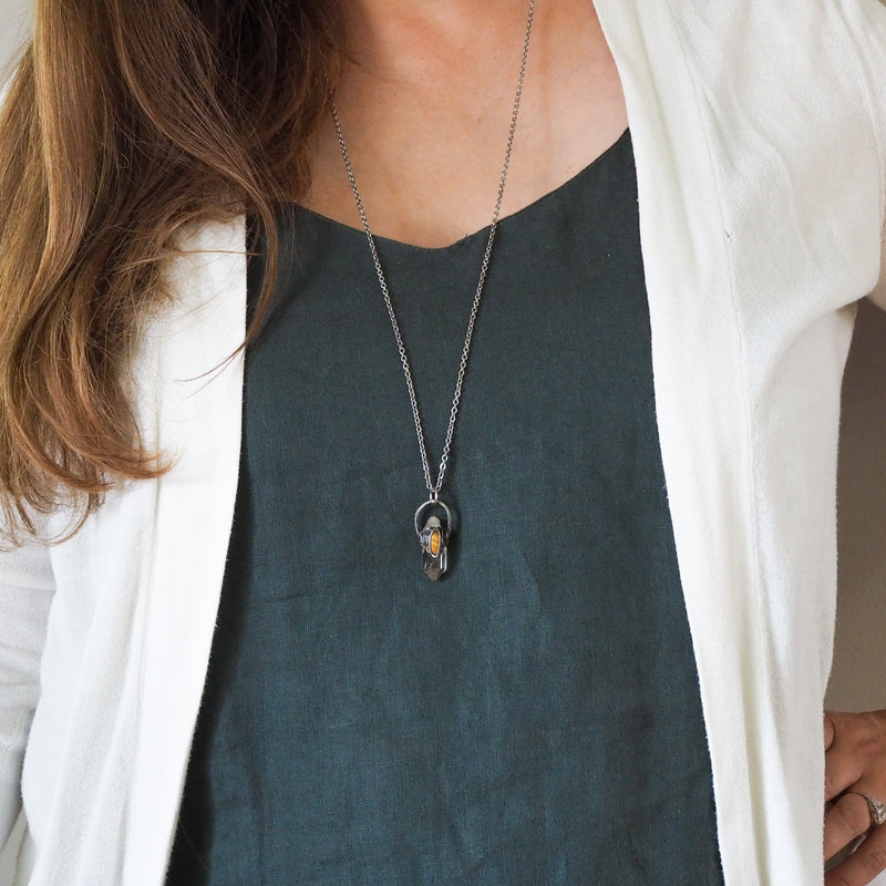 quartz and gold tiger eye healing crystal talisman necklace on woman in blue top