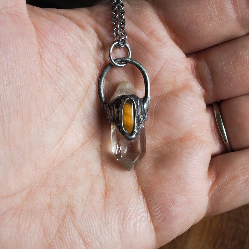quartz and gold tiger eye healing crystal talisman necklace in palm of hand