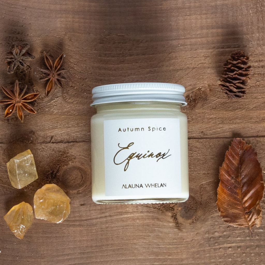 autumn spice luxury soy crystal candle on wooden table with fall foliage