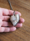 sparkly white healing crystal talisman necklace in palm of hand
