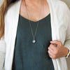 pale blue healing crystal talisman necklace on woman in blue top