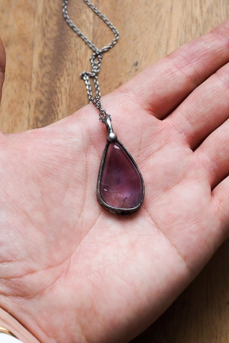 rustic purple amethyst crystal talisman necklace in palm of hand