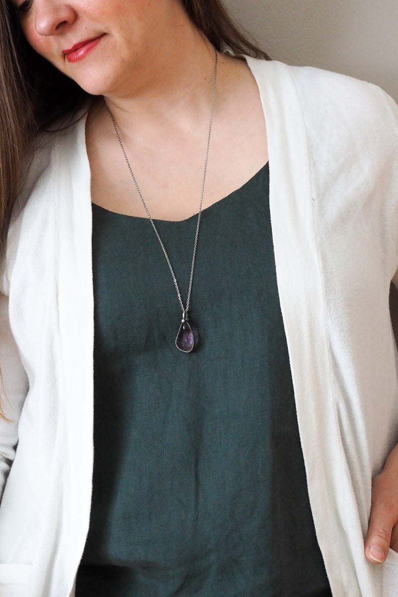 rustic purple amethyst crystal talisman necklace on woman in blue top